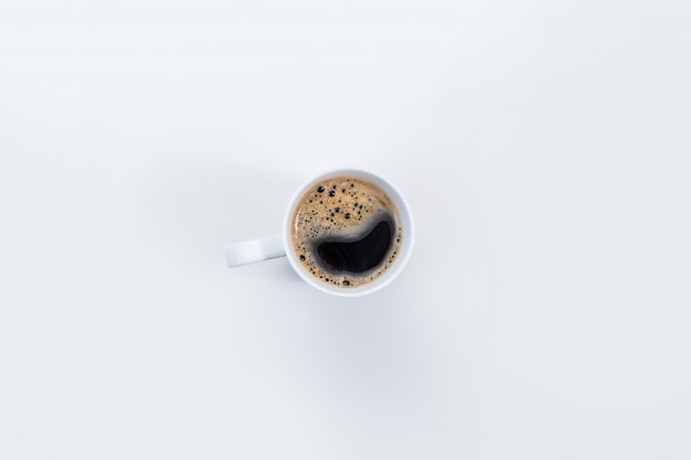 Une tasse de café blanc sur un bureau