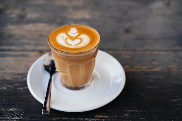 Tasse de café blanc plat sur une table en bois