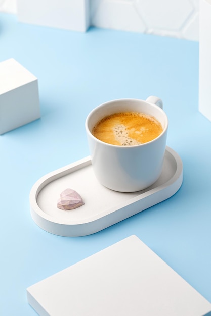 Une tasse à café blanche avec expresso ou cappuccino sur plateau en béton et podiums Aroma Mug of coffee Blue