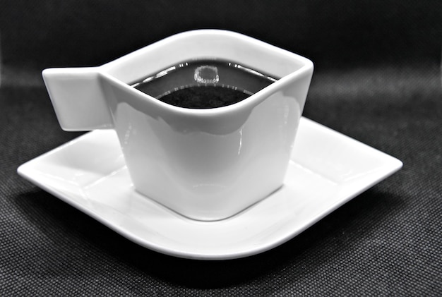 Tasse à café blanche sur fond noir.