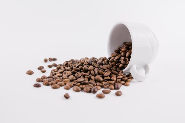 Tasse de café blanche avec des grains de café saupoudrés