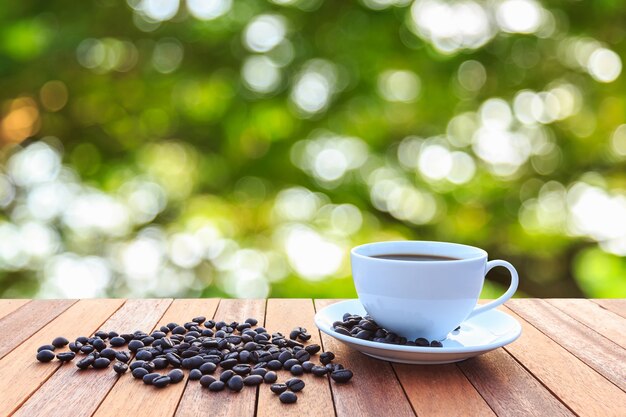 Tasse à café blanche et grains de café sur la table en bois