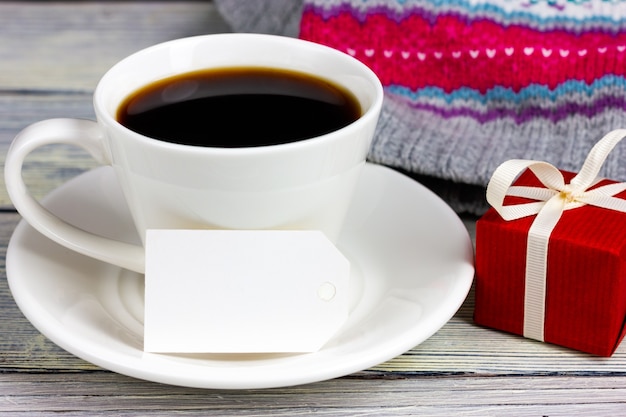 Une tasse de café blanche, une note papier et un petit cadeau rouge. Place pour votre texte. Félicitations pour la Saint Valentin, anniversaire.