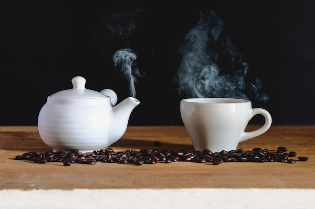 Tasse à café blanche avec pot blanc et torréfacteur sur table.