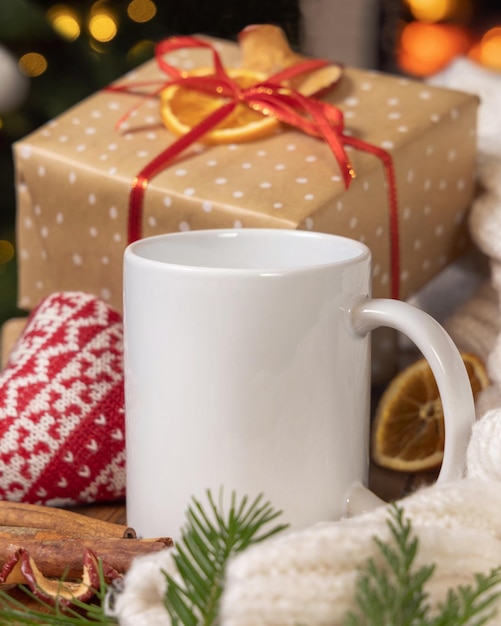 Une tasse de café blanche près du cadeau de Noël, un cœur confortable et un pull d'hiver.