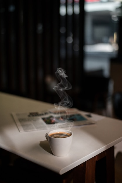 Tasse à café blanche sur la table à l'intérieur du café