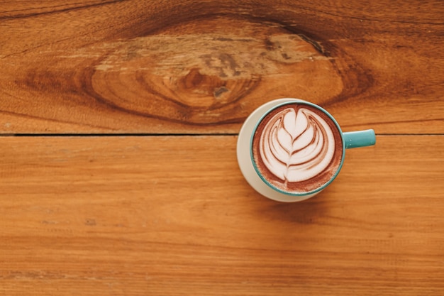 Tasse De Café Bleu Avec Plein D'art Latte Sur Table En Bois