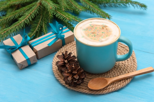 Une tasse de café bleu sur une table en bois bleu clair la nuit de Noël.