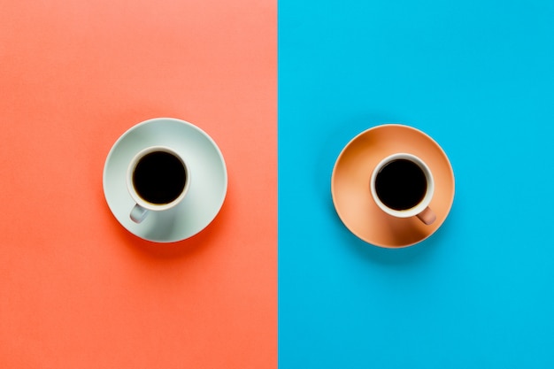 Tasse de café bleue et brune sur un orange coloré et bleu.