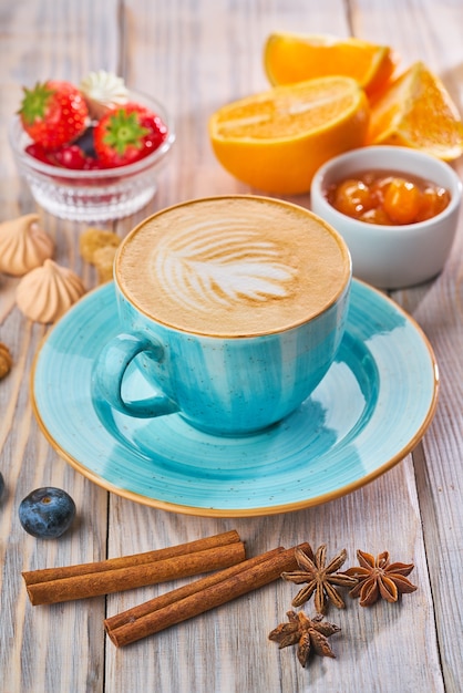 Tasse à café bleue avec cappuccino, cannelle et anis. Concept de petit-déjeuner