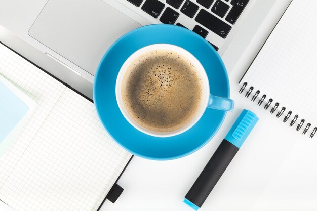 Tasse à café bleue et fournitures de bureau