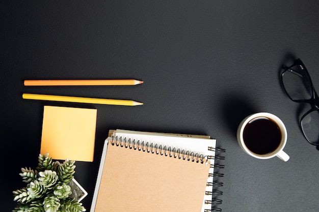 Tasse de café avec bloc-notes et crayons avec du papier sur la table