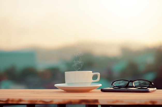 Une tasse de café, des boissons chaudes et des cigarettes sur la table le matin