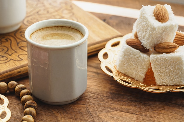 Tasse à café avec des bonbons orientaux sur la table en bois se bouchent