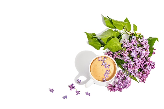 Tasse de café et bouquet de fleurs lilas isolé sur fond blanc Concept de petit-déjeuner printemps