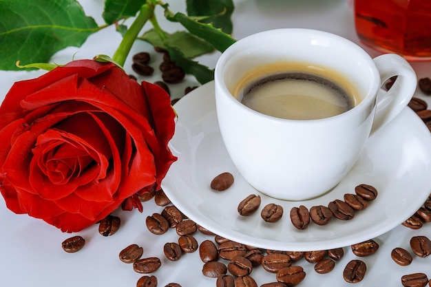 Tasse de café et bouquet de roses rouges. Grains de café éparpillés sur la table. Bonjour.