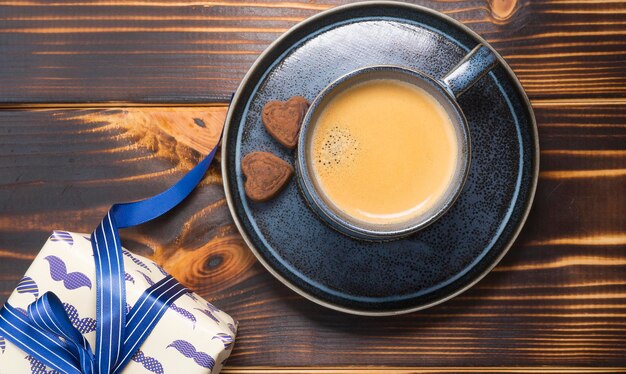 Tasse à café et un cadeau pour un homme sur un fond en bois