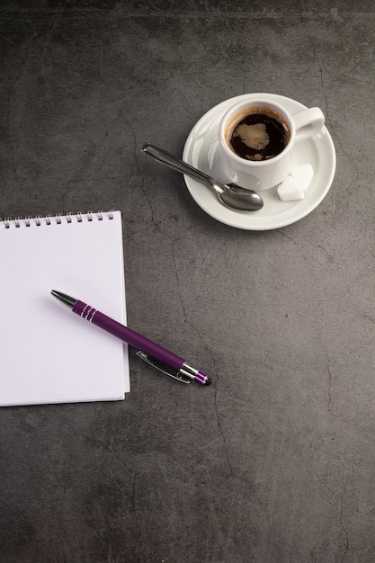 Tasse à café avec un cahier et un stylo