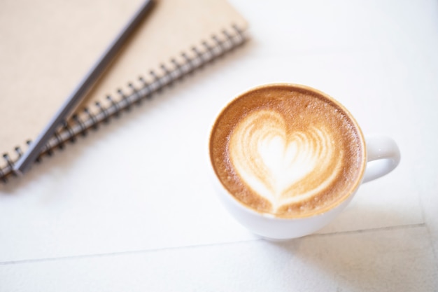 Tasse à café avec cahier sur table