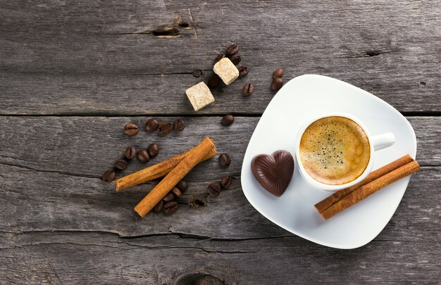 Tasse de café à la cannelle et au sucre sur un fond en bois