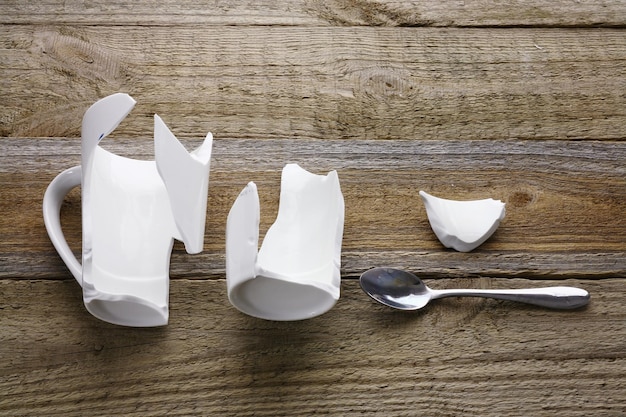 Tasse à café cassée sur fond de bois