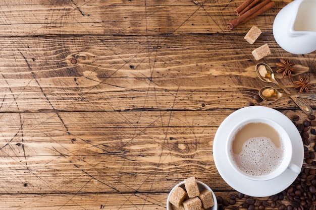 Tasse de café, cassonade et cannelle avec anis sur bois