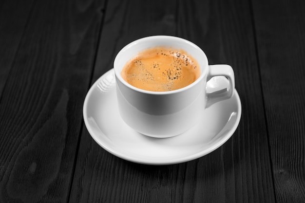 Tasse de café avec de la cassonade sur une table en bois.