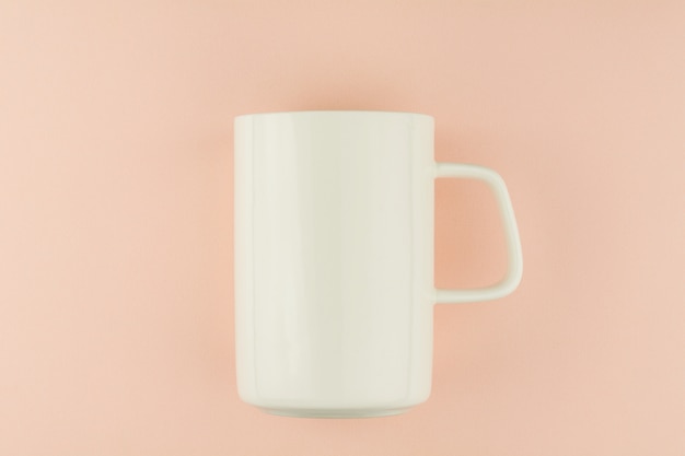 Tasse à café en céramique blanche sur fond rose.