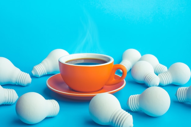 tasse de café chaud et ampoule sur bleu