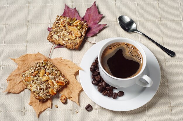 Tasse de café chaud et biscuits aux noix sur table avec nappe