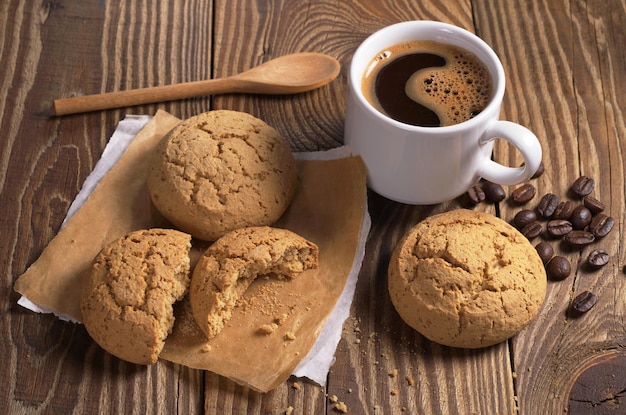 Tasse de café chaud et de biscuits à l'avoine sucrés sur une table en bois rustique