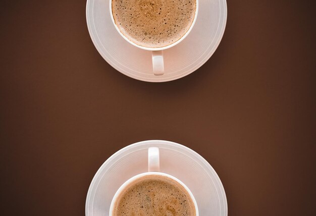 Tasse de café chaud comme petit-déjeuner boire des tasses à plat sur fond marron