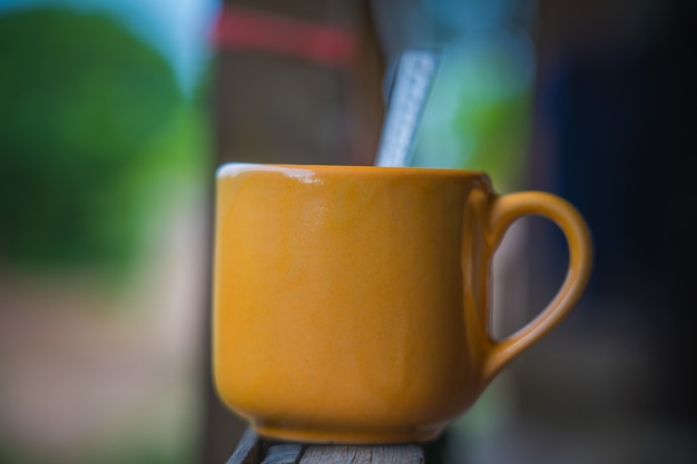 La tasse de café chaud dans le café du jardin avec l&#39;arrière-plan flou de bokeh et un espace pour mettre du texte