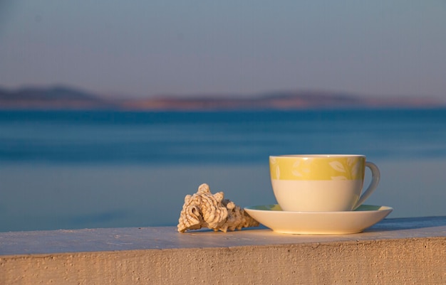 Tasse de café chaud du matin avec coquillage bonjour