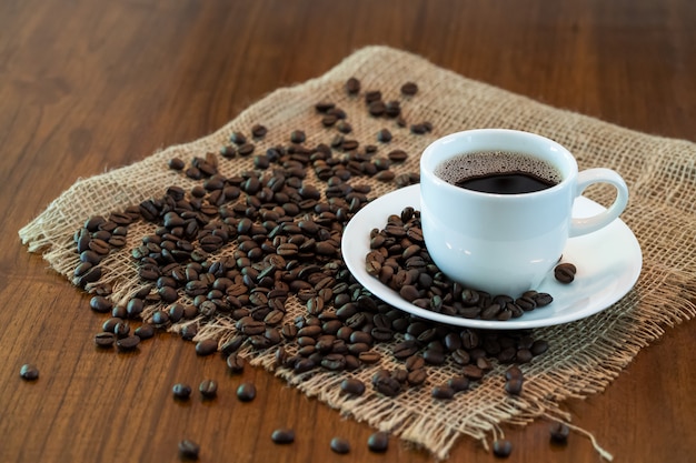 Tasse de café chaud avec des grains de café torréfiés