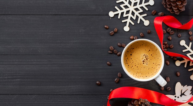 Tasse de café chaud sur une surface en bois noire à Noël