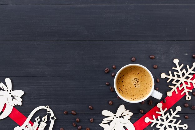 Tasse de café chaud sur une surface en bois noire à Noël