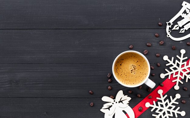 Tasse de café chaud sur une surface en bois noire à Noël