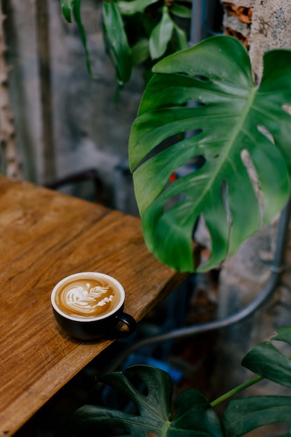 Photo une tasse de café chaud sur une table en bois