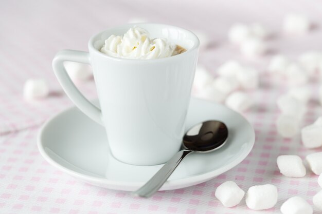 Tasse de café ou de chocolat chaud avec de la crème fouettée sur la table au café