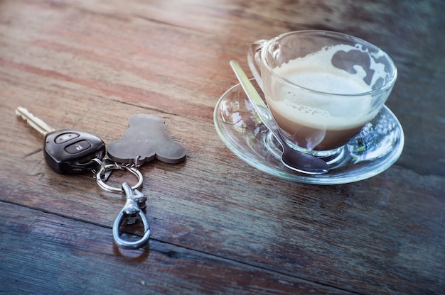 Tasse à café et clés de voiture sur la table en bois.