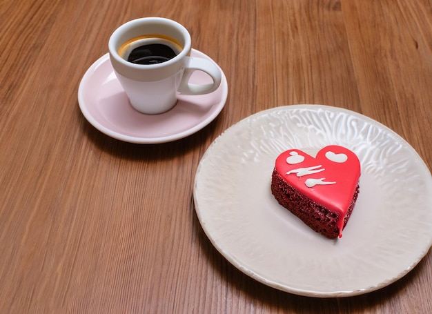 tasse de café avec un coeur sur une assiette avec un gâteau