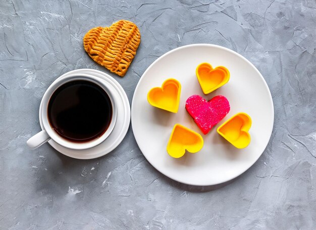 tasse de café avec un coeur sur une assiette avec un gâteau