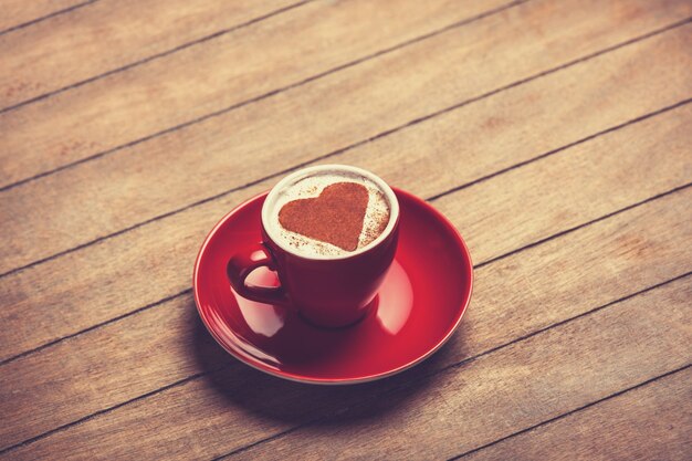 Tasse de café avec coeur de forme sur une table en bois