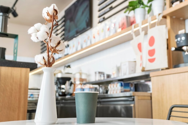 tasse à café en coton et papier en fleurs sur une table dans un café avec un arrière-plan flou