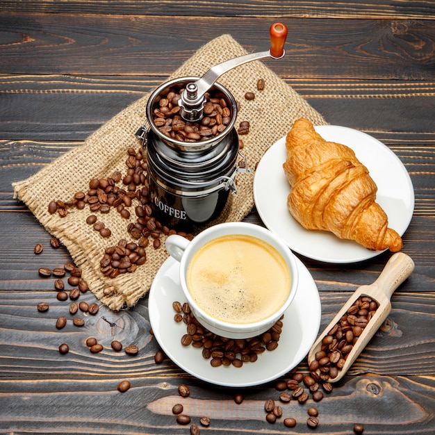 Tasse de café et croissant sur fond en bois