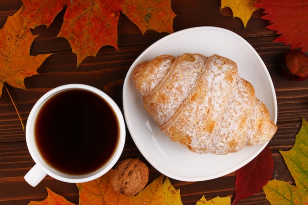 Tasse de café et croissant nature morte d'automne