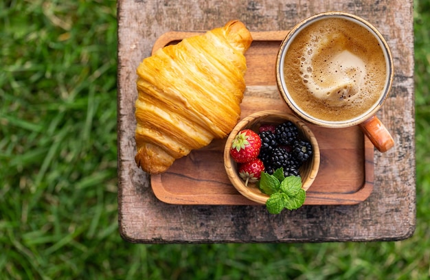 Tasse à café et croissant sur table de jardin extérieur