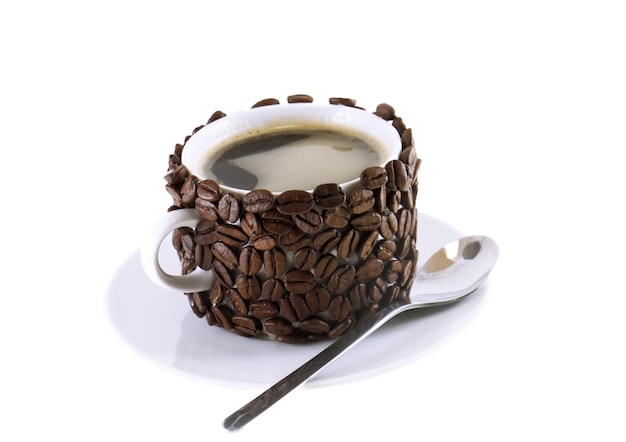 La tasse de café et la cuillère, décorée de grains de café. Isolé