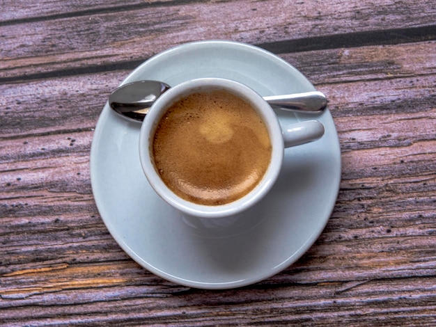 Tasse de café avec une cuillère sur un fond rustique.